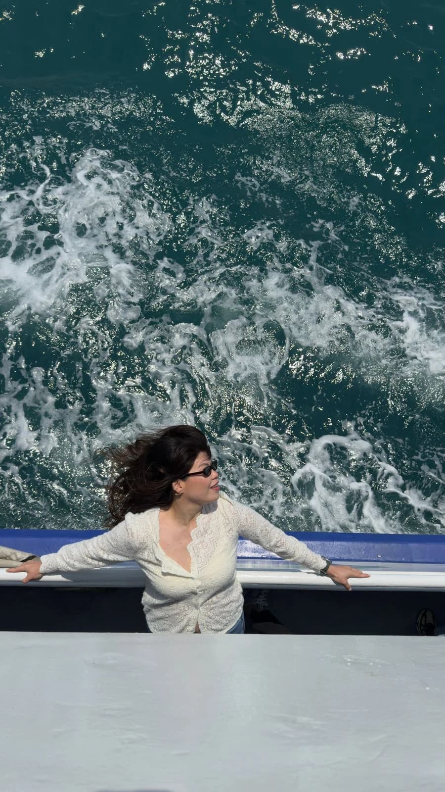 Woman posing on an Istanbul ferry deck above the foamy Bosphorus wake